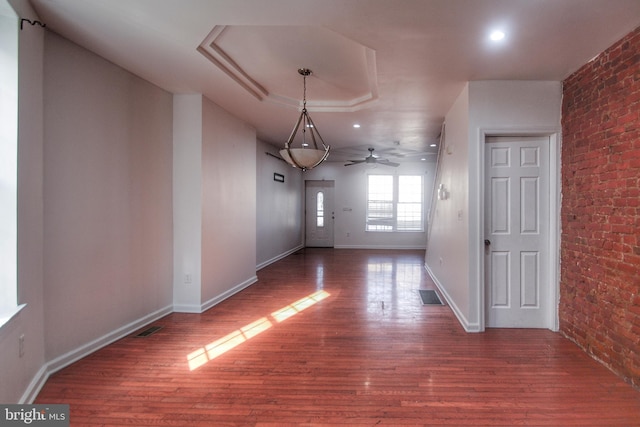 unfurnished dining area featuring hardwood / wood-style flooring and brick wall