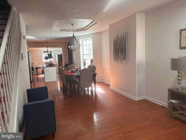 dining space featuring dark hardwood / wood-style floors and a raised ceiling