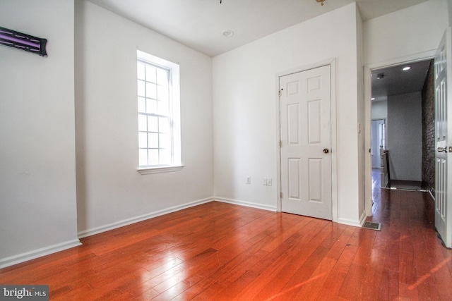 unfurnished bedroom with dark hardwood / wood-style flooring