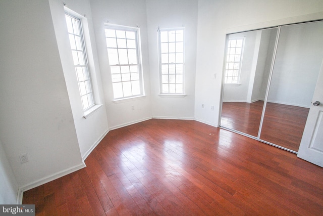 unfurnished bedroom featuring dark hardwood / wood-style flooring and a closet