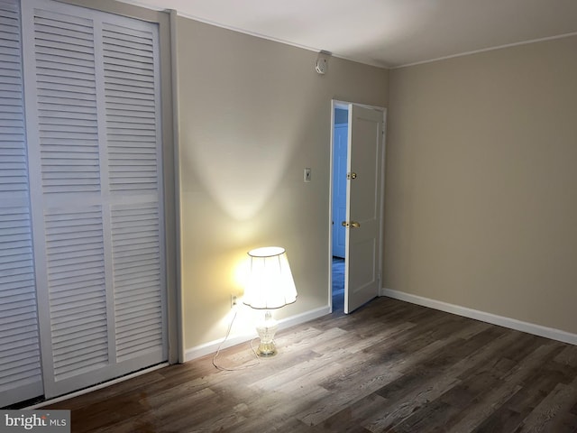 unfurnished bedroom featuring dark hardwood / wood-style floors and a closet