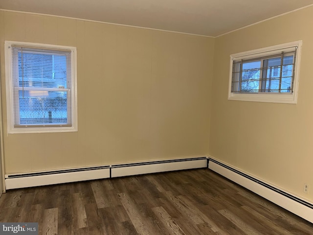 unfurnished room featuring baseboard heating and dark hardwood / wood-style floors