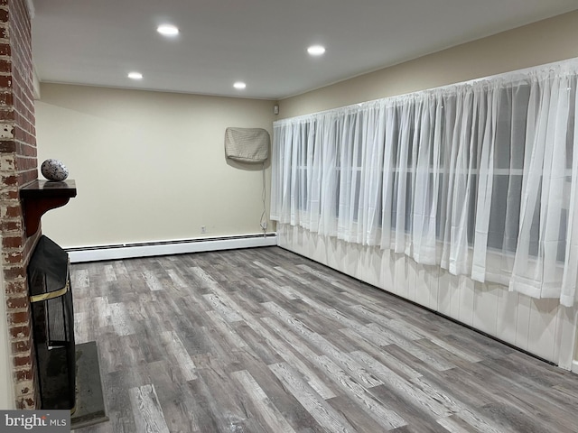 unfurnished room featuring a baseboard radiator and wood-type flooring