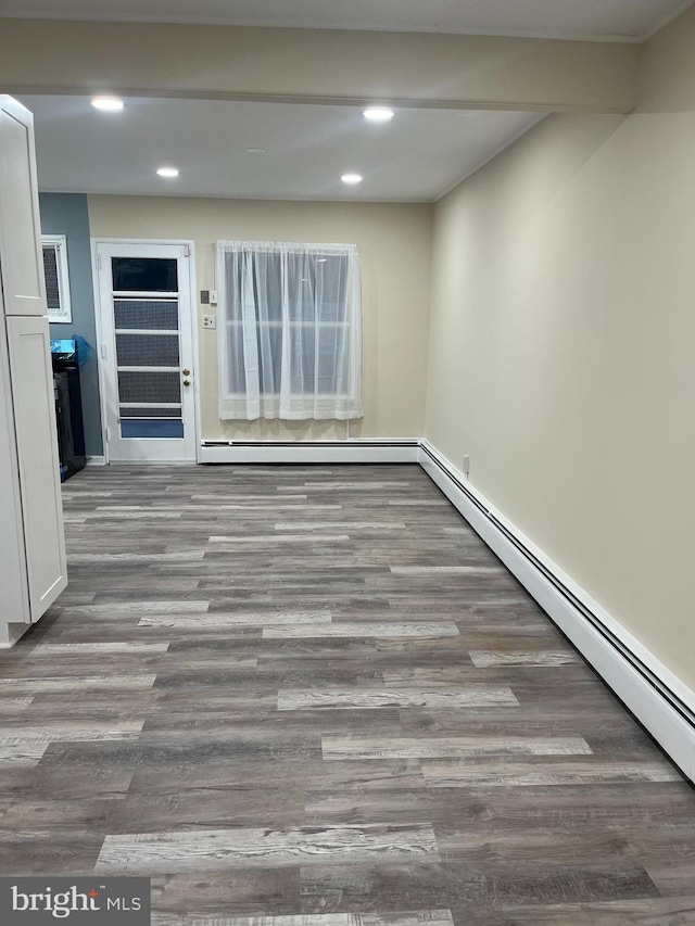 unfurnished room with a baseboard radiator and wood-type flooring