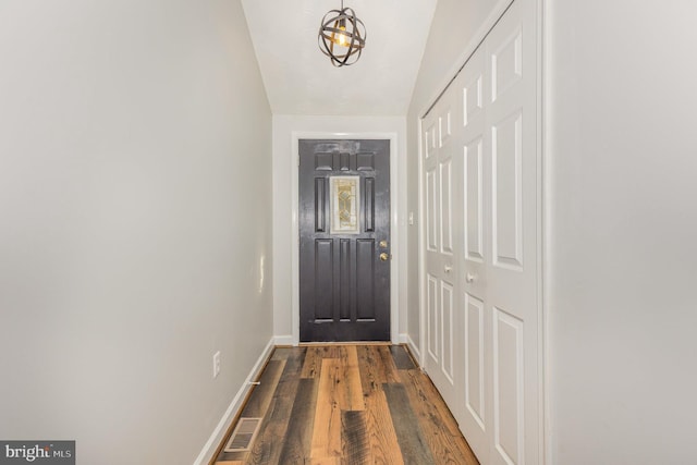 doorway with dark wood-type flooring and vaulted ceiling