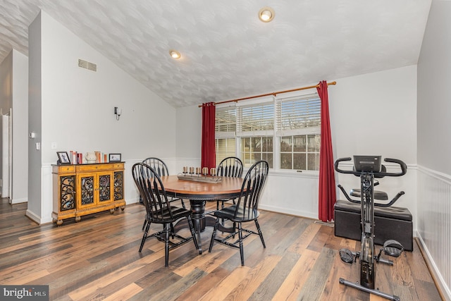 dining space with lofted ceiling and hardwood / wood-style floors