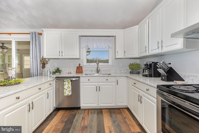 kitchen featuring sink, range hood, stainless steel appliances, light stone countertops, and white cabinets