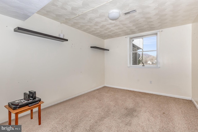 spare room featuring carpet and a textured ceiling