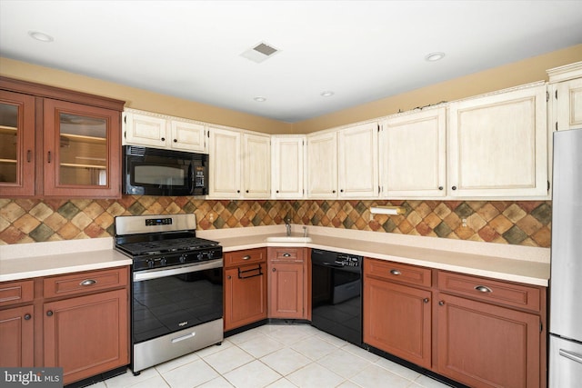 kitchen with glass insert cabinets, light countertops, and black appliances