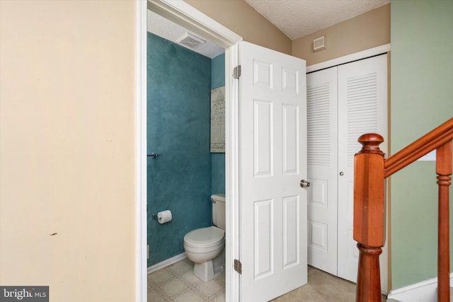 bathroom featuring visible vents, a textured ceiling, toilet, and baseboards