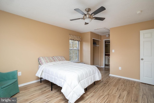 bedroom with a textured ceiling, a closet, ceiling fan, and light wood-type flooring