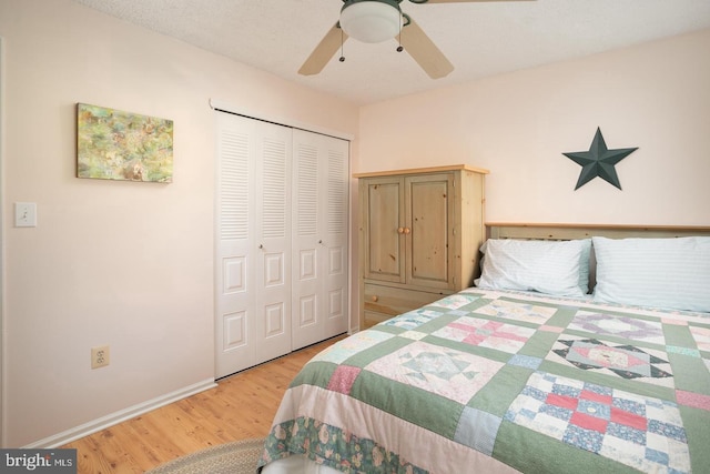 bedroom featuring ceiling fan, a closet, wood finished floors, and baseboards