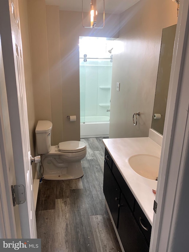 full bathroom featuring vanity, wood-type flooring, shower / bathtub combination, and toilet