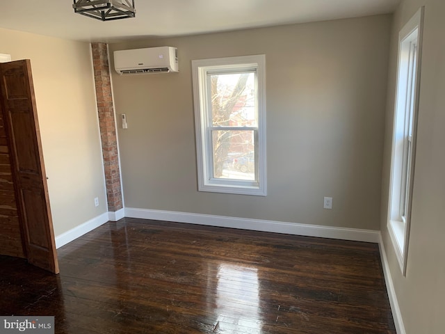 unfurnished room featuring a wall mounted air conditioner and dark hardwood / wood-style flooring