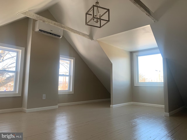 additional living space featuring lofted ceiling, light wood-type flooring, and an AC wall unit