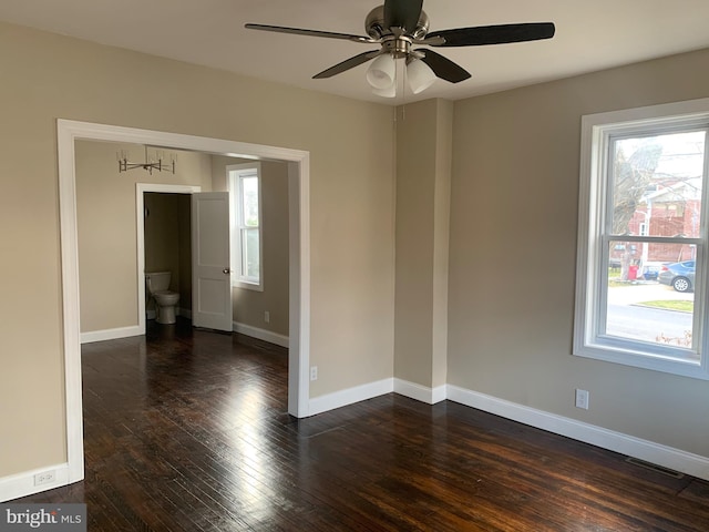 empty room with ceiling fan and dark hardwood / wood-style flooring