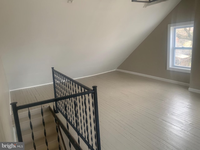 additional living space featuring lofted ceiling and wood-type flooring