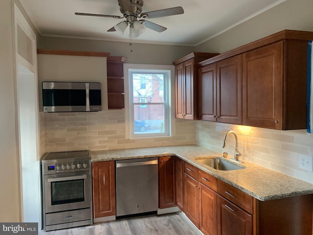 kitchen with sink, crown molding, stainless steel appliances, light hardwood / wood-style floors, and light stone countertops