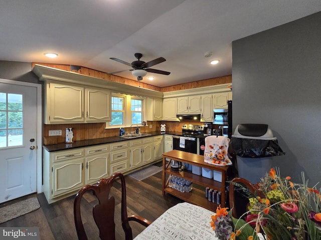 kitchen featuring dark wood-type flooring, sink, stainless steel range with electric stovetop, ceiling fan, and decorative backsplash