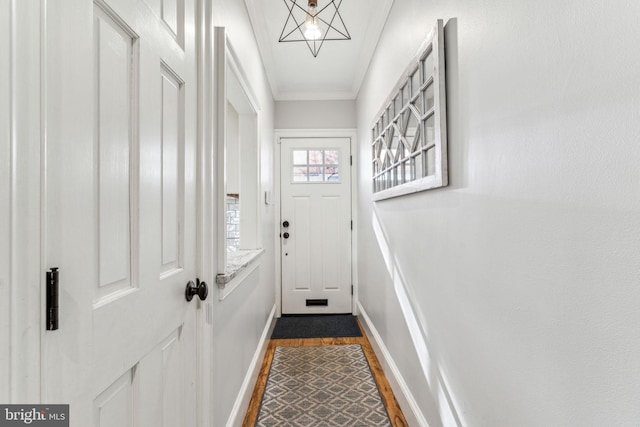 doorway with dark hardwood / wood-style flooring and crown molding