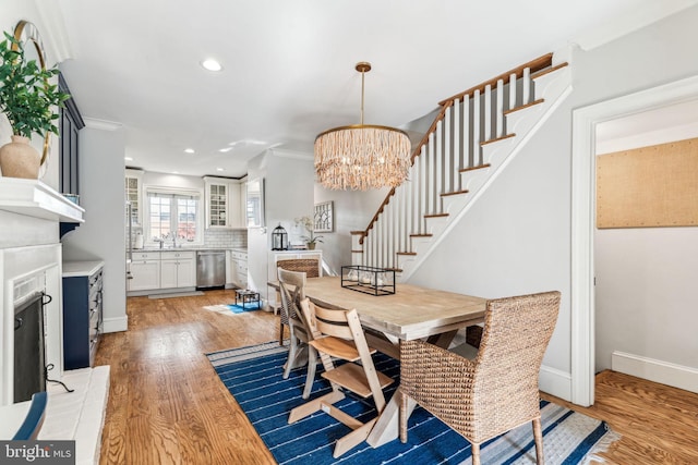 dining room featuring an inviting chandelier, ornamental molding, and light hardwood / wood-style floors