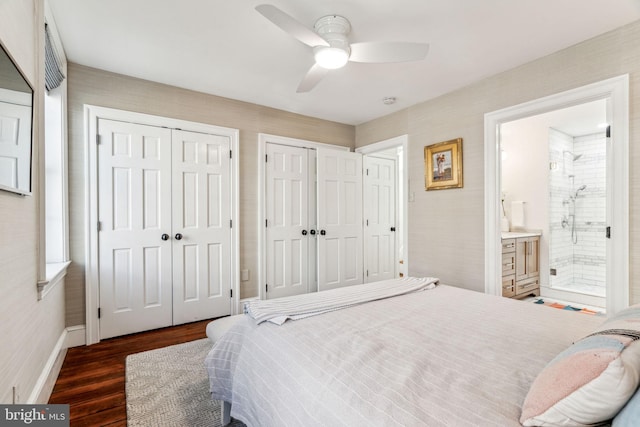 bedroom featuring multiple closets, ceiling fan, ensuite bathroom, and dark wood-type flooring