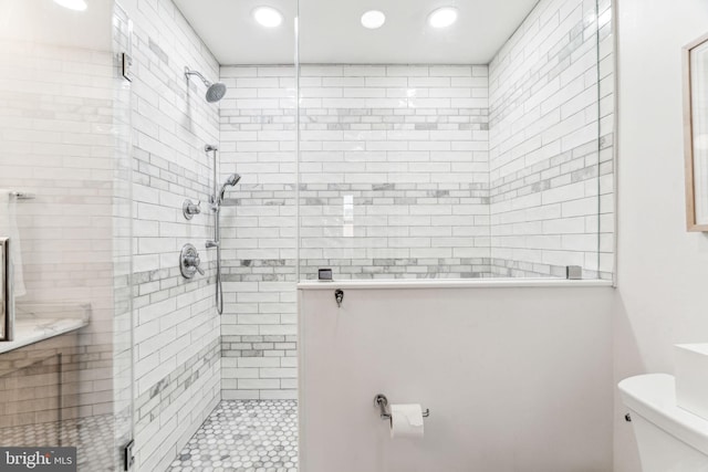 bathroom with toilet and a shower with shower door