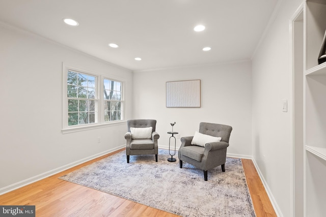 living area featuring hardwood / wood-style flooring and ornamental molding