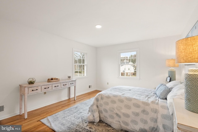 bedroom featuring multiple windows and light hardwood / wood-style floors