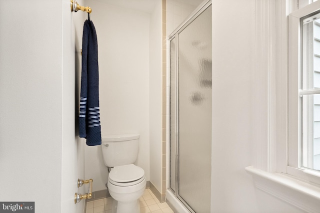 bathroom featuring walk in shower, tile patterned floors, and toilet