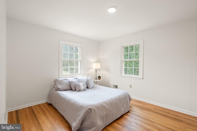 bedroom featuring hardwood / wood-style flooring and multiple windows