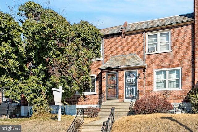 view of property featuring a front yard and cooling unit