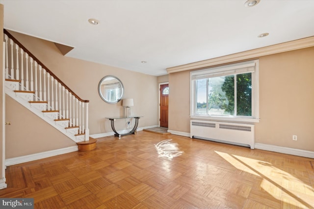 entryway with parquet flooring and radiator heating unit