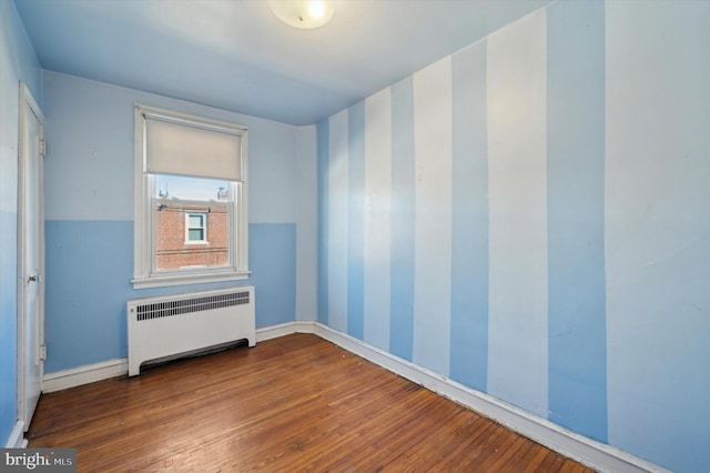 empty room with radiator and hardwood / wood-style floors