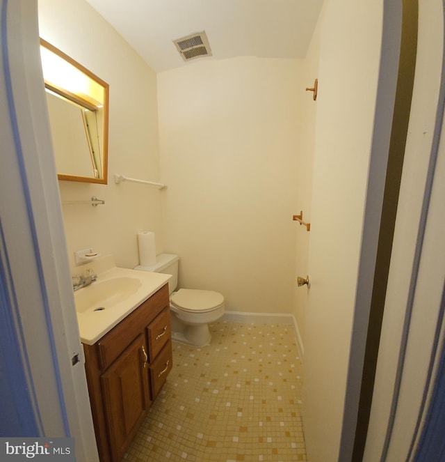 bathroom with baseboards, visible vents, vanity, and toilet