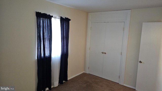 unfurnished bedroom with multiple windows, carpet floors, and a closet