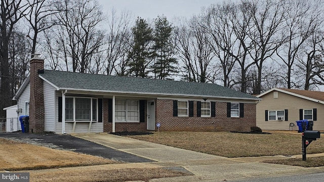 single story home with roof with shingles, a chimney, and brick siding