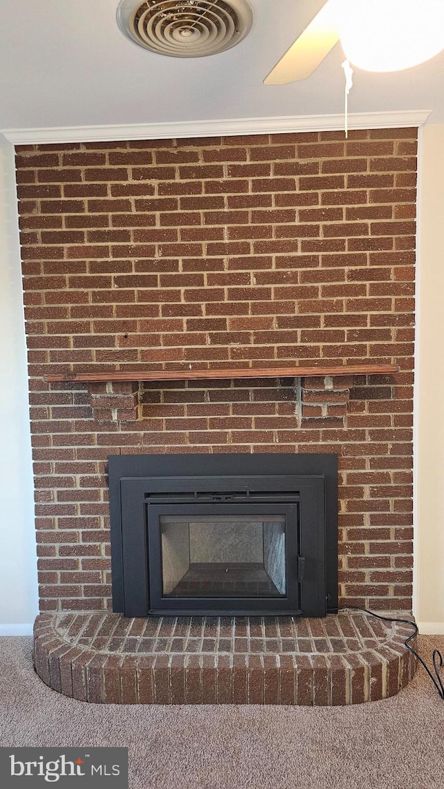 details with a fireplace, carpet flooring, visible vents, and crown molding