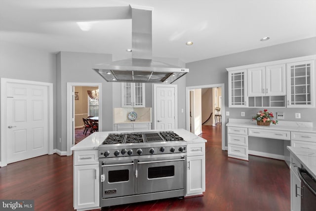 kitchen featuring dishwashing machine, range with two ovens, island range hood, dark wood-type flooring, and white cabinets