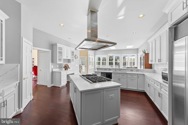 kitchen with stainless steel appliances, tasteful backsplash, a center island, and island range hood