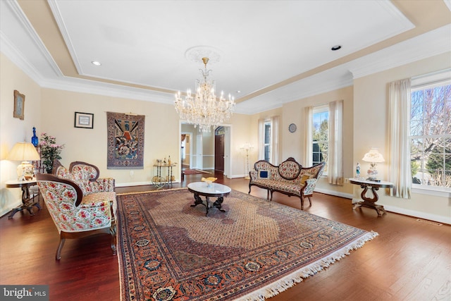 living area featuring ornamental molding, baseboards, and wood finished floors