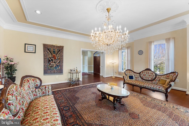 living room with baseboards, a chandelier, wood finished floors, and crown molding