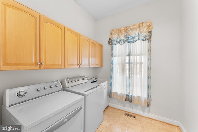 laundry room featuring visible vents, washing machine and dryer, cabinet space, and baseboards