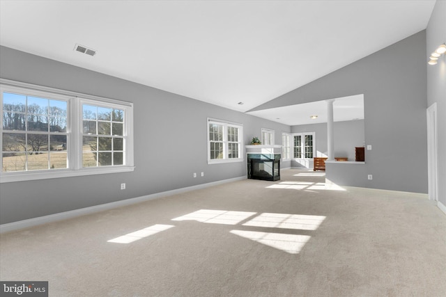 unfurnished living room with visible vents, baseboards, carpet, a fireplace, and high vaulted ceiling