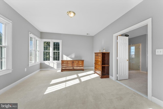 unfurnished bedroom with carpet floors, multiple windows, and baseboards