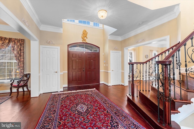 entrance foyer with baseboards, crown molding, stairway, and wood finished floors