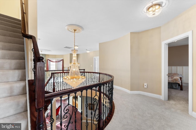 hall featuring visible vents, baseboards, stairway, carpet floors, and a chandelier