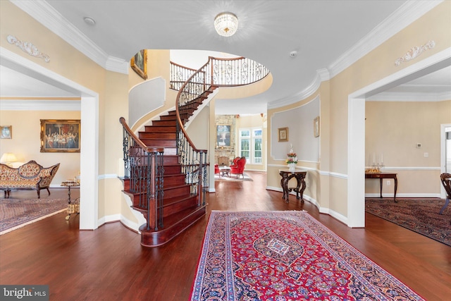 entryway featuring baseboards, stairs, ornamental molding, and wood finished floors