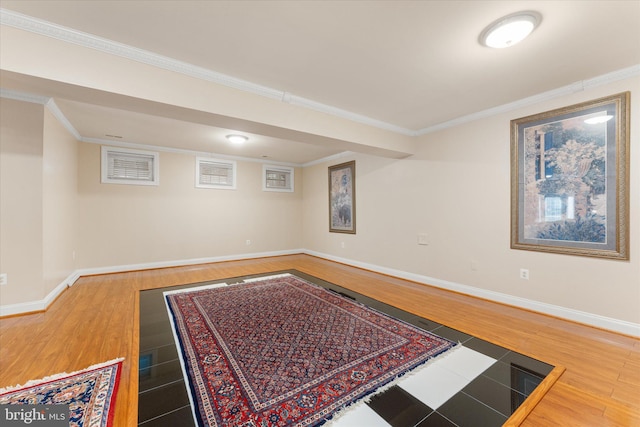 interior space featuring crown molding, baseboards, and wood finished floors