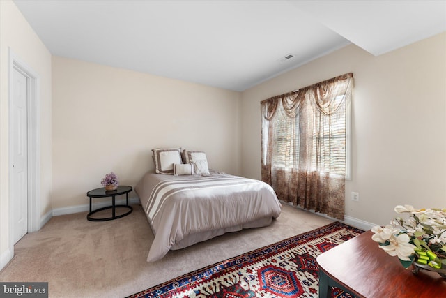 bedroom featuring carpet floors, visible vents, and baseboards